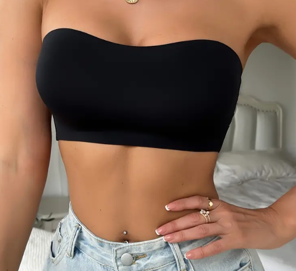 Close-up of a black strapless bandeau top styled with light-wash denim shorts, showcasing a sleek and minimalist look ideal for casual or summer outfits. Accessories include layered gold necklaces and rings.