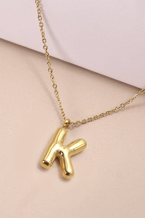 "Gold-tone necklace featuring a puffed, balloon-style pendant in the shape of the letter 'K,' suspended from a delicate gold chain. Stylish and minimalistic, ideal for personalizing any outfit."