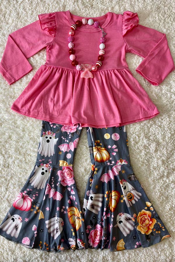 Adorable children's outfit featuring a pink long-sleeve peplum top with ruffle details on the shoulders, paired with flared bell-bottom pants in a Halloween-themed print. The pants feature cheerful ghosts, pumpkins, bats, and floral designs on a gray background. A matching chunky bead necklace with pink and red tones completes the festive look.