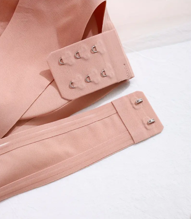 Detailed shot of a nude elastic band with multiple hook closures, showcasing versatility and adaptability for different sizes and styles.