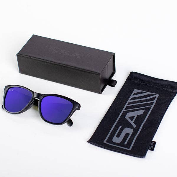 A product set featuring black sunglasses with vibrant blue mirrored lenses, a sleek black protective carrying pouch with a bold "SA" logo in gray, and a matching black box with subtle embossed branding. The sunglasses have a classic wayfarer-style frame, ideal for a modern, sporty look.