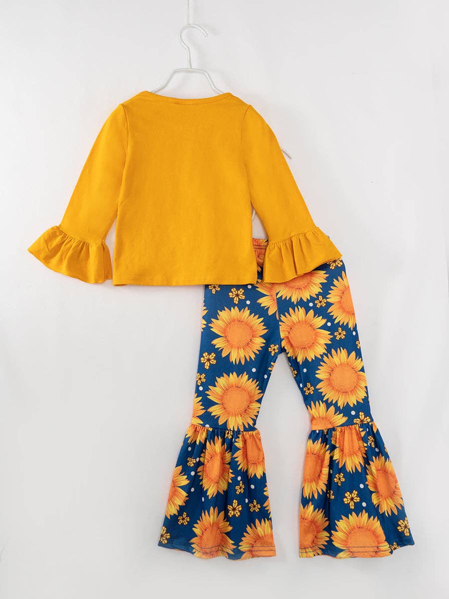 Bright and cheerful girls' outfit featuring a mustard yellow long-sleeve top with ruffle bell sleeves, paired with navy blue bell-bottom pants decorated with bold orange sunflower prints. Perfect for adding a vibrant, autumn-inspired look to any wardrobe.