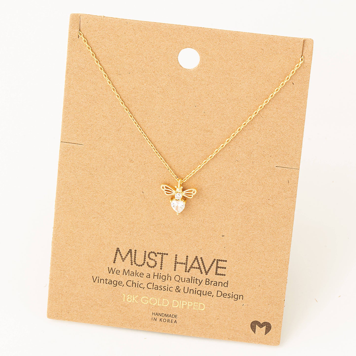 A dainty gold necklace featuring a bee-shaped pendant with intricate details. The pendant includes delicate gold wings and a pear-shaped crystal body that adds sparkle and charm. The necklace is displayed on a minimalist kraft paper backing card with the text "MUST HAVE," highlighting it as "18K Gold Dipped" and emphasizing its "Vintage, Chic, Classic & Unique" design. The card also notes that it is "Handmade in Korea," making it a thoughtful accessory or gift choice.