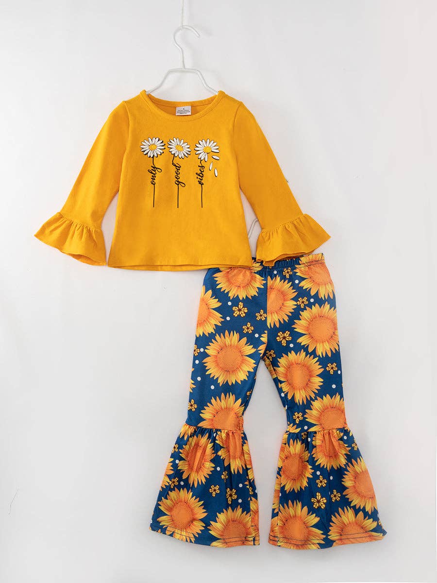 Adorable girls' ensemble with a mustard yellow long-sleeve top featuring ruffle bell sleeves and a daisy graphic with the phrase 'Only Good Vibes.' Paired with flared bell-bottom pants in a navy blue sunflower print, this outfit blends charm and comfort with a nature-inspired theme.