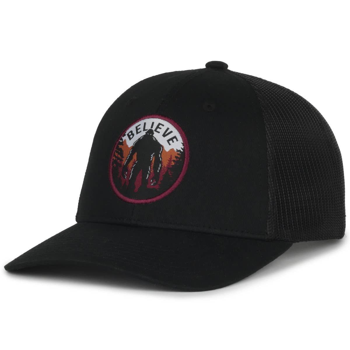 A black trucker-style cap featuring a curved brim and a mesh back. The front panel displays a circular embroidered patch with an illustration of a Bigfoot silhouette against a forest and sunset background. The text "BELIEVE" is stitched above the image, emphasizing a playful nod to the Bigfoot legend. The design combines an outdoorsy, mysterious aesthetic with casual style.