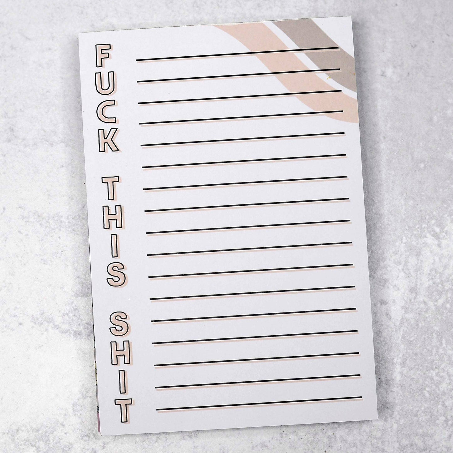 A lined notepad with "FUCK THIS SHIT" written vertically in bold tan letters with black outlines along the left margin. The background includes a minimalist, abstract design in soft beige and white tones.