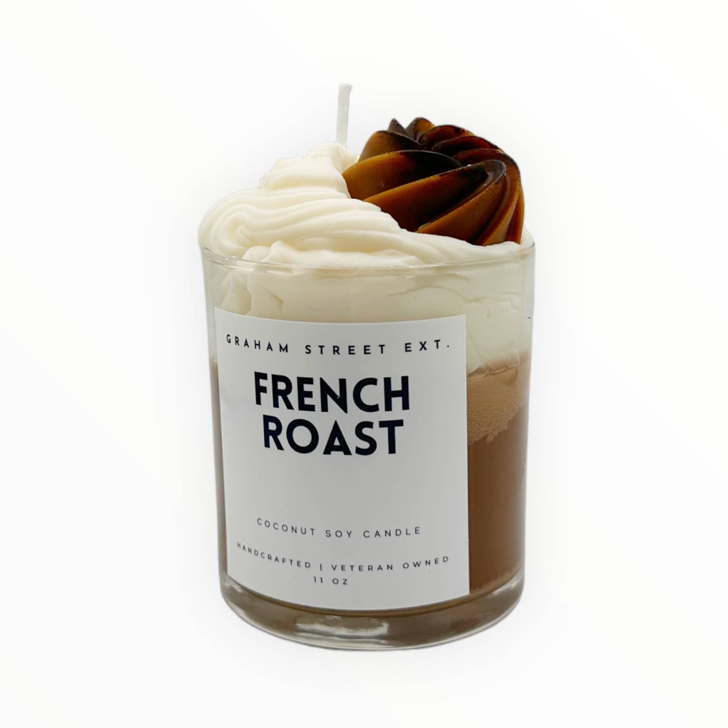 A handcrafted 11 oz coconut soy candle labeled "Graham Street Ext. French Roast." The design mimics a rich coffee drink, featuring whipped cream-style wax swirls on top with a dark coffee-colored accent resembling roasted beans. Veteran-owned branding emphasizes quality and craftsmanship, making it ideal for coffee lovers or as a cozy, aromatic gift.