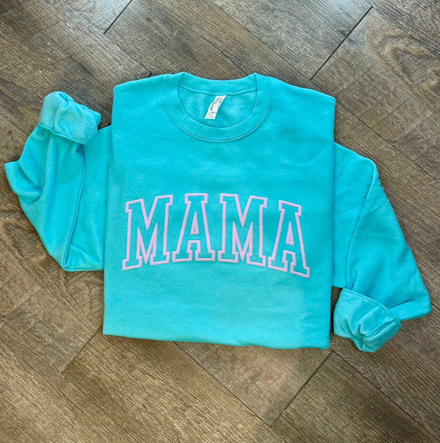 Stylish Mama crewneck sweatshirt for women, featuring a comfortable and relaxed fit with a bold 'Mama' graphic design. Perfect for casual wear or lounging, this soft sweatshirt offers warmth and cozy comfort. Made from high-quality fabric, it pairs effortlessly with jeans, leggings, or shorts for an easy, chic look. Available in various sizes and colors, this crewneck sweatshirt is a must-have for moms looking for both comfort and style in their everyday wardrobe
