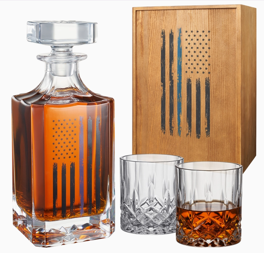 Crystal whiskey decanter and glasses set featuring an etched American flag design, accompanied by a wooden box with a matching flag motif.