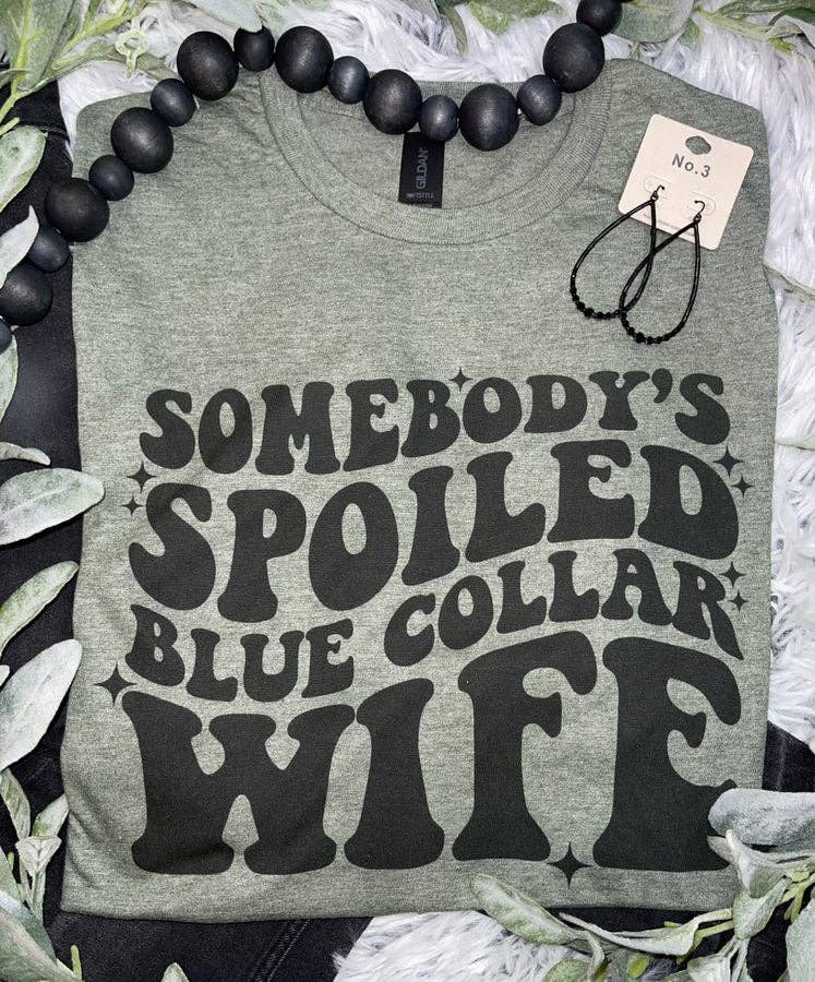Olive green t-shirt with 'Somebody's Spoiled Blue Collar Wife' text, funny graphic tee, proud wife slogan shirt, casual statement shirt for blue-collar pride, comfortable unisex tee, trendy green shirt for everyday wear