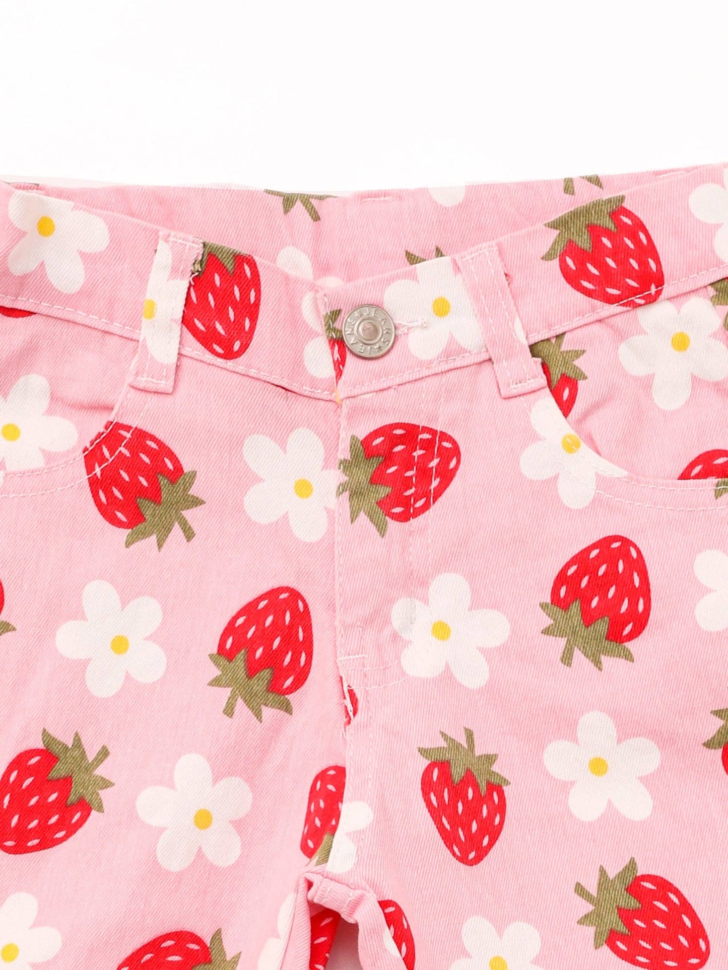Close-up of pink flared pants featuring a playful pattern of red strawberries and white daisies with green accents. The pants have belt loops, a button closure, and a fun, vibrant design.