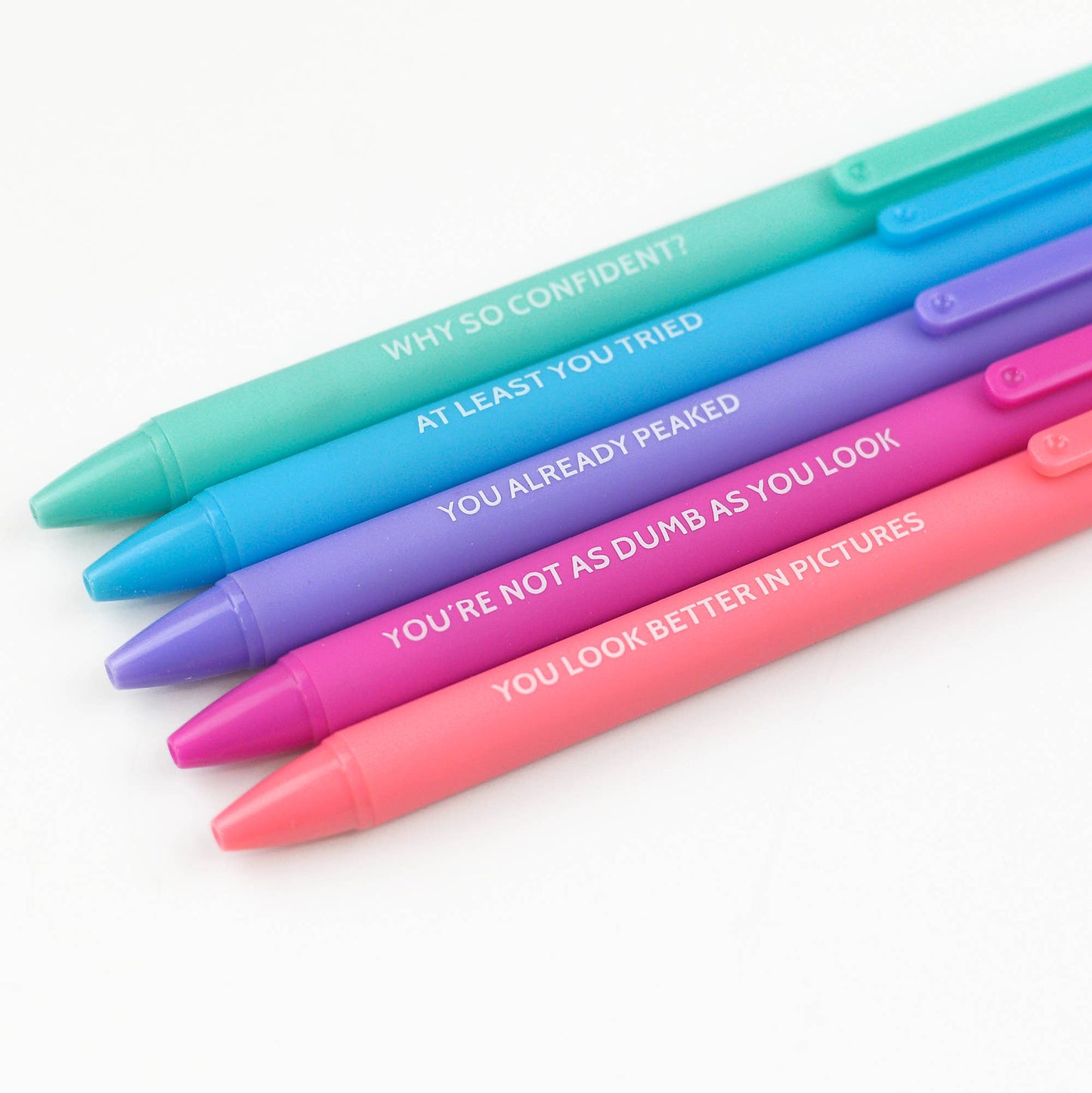Brightly colored pen set with witty phrases like 'At least you tried' and 'You’re not as dumb as you look,' packaged in a vibrant pink box. Perfect for fun office supplies or as a humorous gift for coworkers.