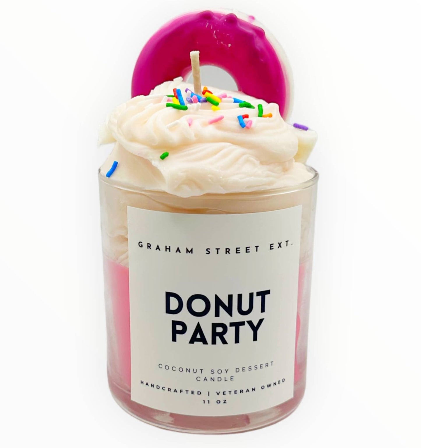 Fun dessert-inspired candle labeled "DONUT PARTY," handcrafted with coconut soy wax. The candle features whipped wax "frosting" topped with colorful sprinkles and a vibrant pink donut accent, making it a playful and decorative piece. Perfect for sweet scent lovers.