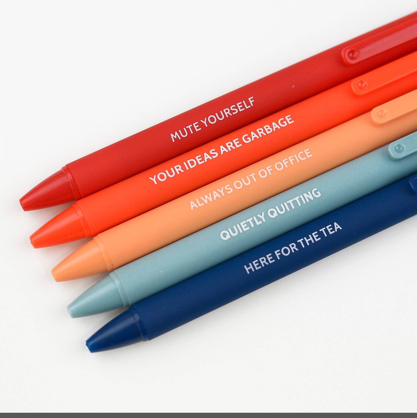Colorful office pen set featuring phrases like 'Mute Yourself,' 'Quietly Quitting,' and 'Here for the Tea,' packaged in a cream-colored box. A humorous take on workplace essentials, ideal for gifts or personal use.
