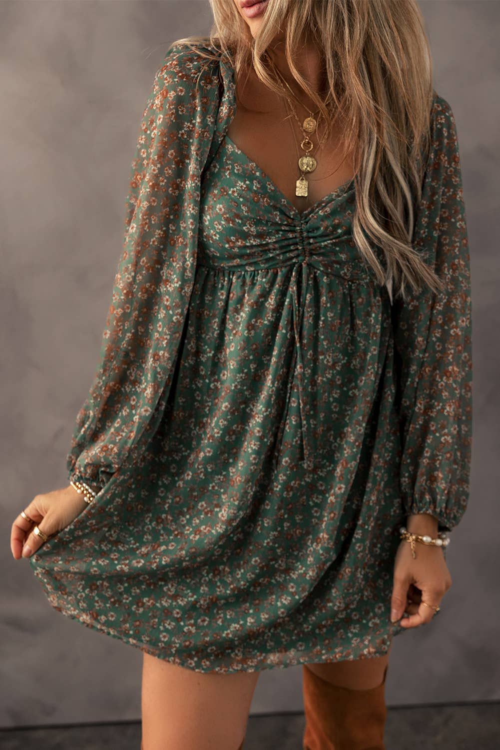 Boho-chic green floral dress with long sheer sleeves, ruched bodice, and flowy silhouette. Perfect casual fall fashion for women looking for a vintage-inspired look with earthy tones. Ideal for layering with jewelry and boots to create a trendy, feminine outfit