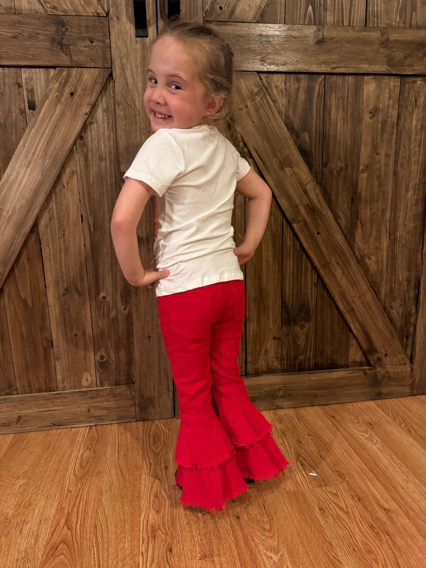 Rory modeling red double-layered bell-bottom jeans for kids, showcasing a bold and trendy flared design, paired with a confident pose, perfect for highlighting fashionable and comfortable children's clothing
