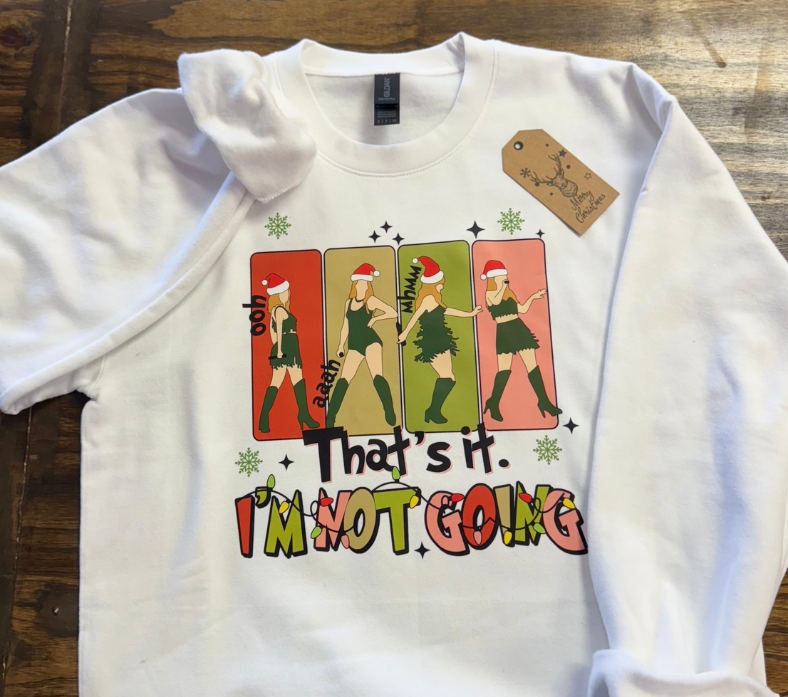 White holiday sweatshirt with a colorful Taylor Swift -inspired graphic reading a Grinch inspired phrase 'That's It. I'm Not Going,' featuring Santa hat designs.