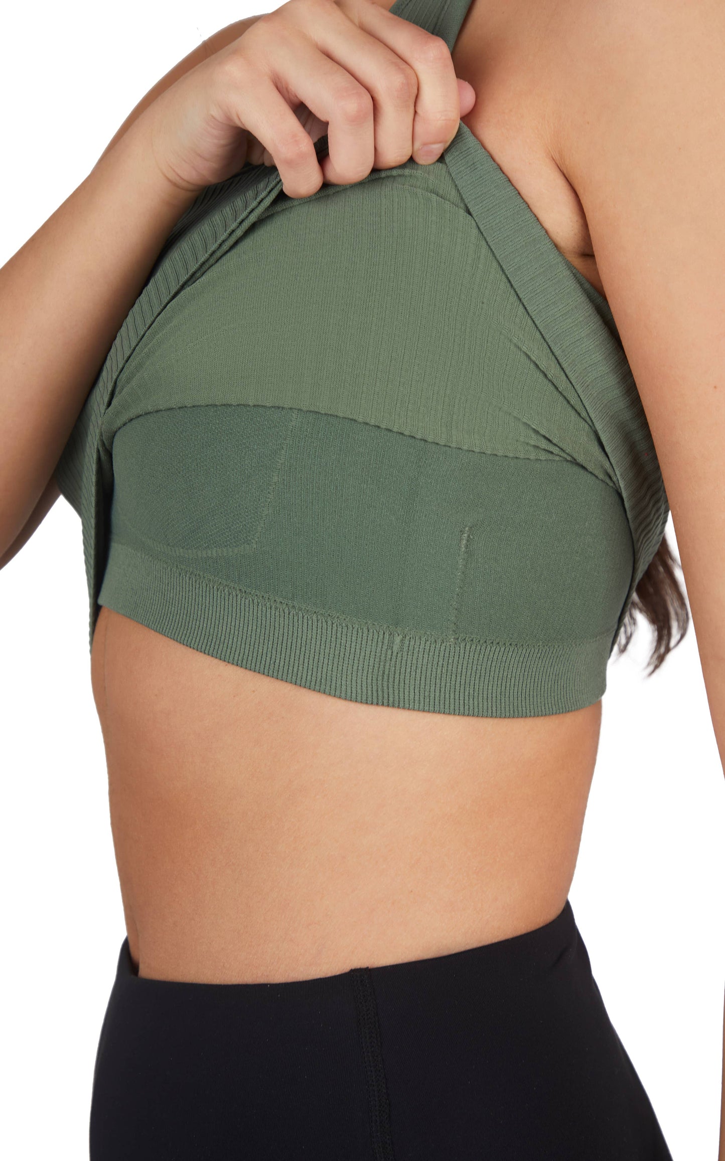 A woman wearing a ribbed, racerback cropped tank top in sage green paired with high-waisted black leggings. The outfit highlights a sleek and casual activewear look, suitable for workouts or everyday athleisure style. The plain white background keeps the focus on the clothing.