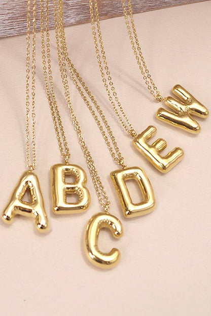 "Gold-tone necklace featuring a puffed, balloon-style pendant in the shape a letter suspended from a delicate gold chain. Stylish and minimalistic, ideal for personalizing any outfit."
